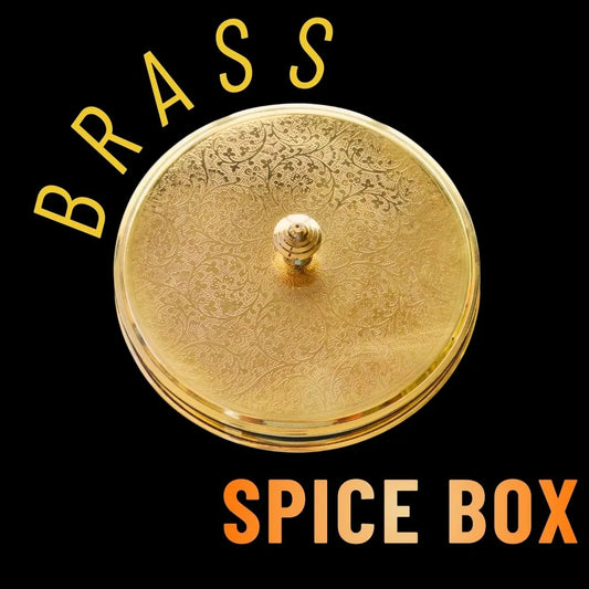 Decorative brass spice box with intricate designs on a black background