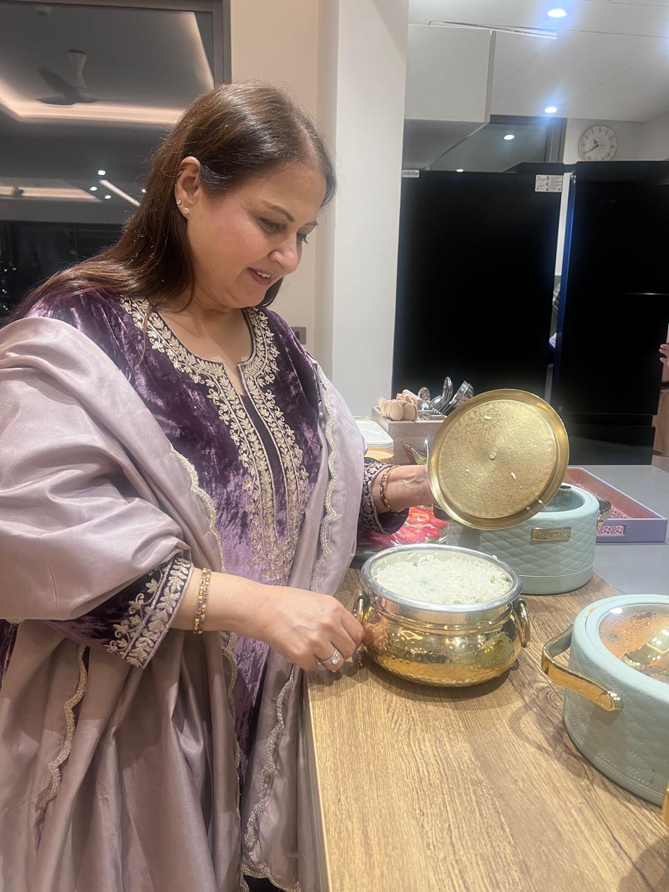 Woman in a kitchen setting, interacting with kitchenware.
