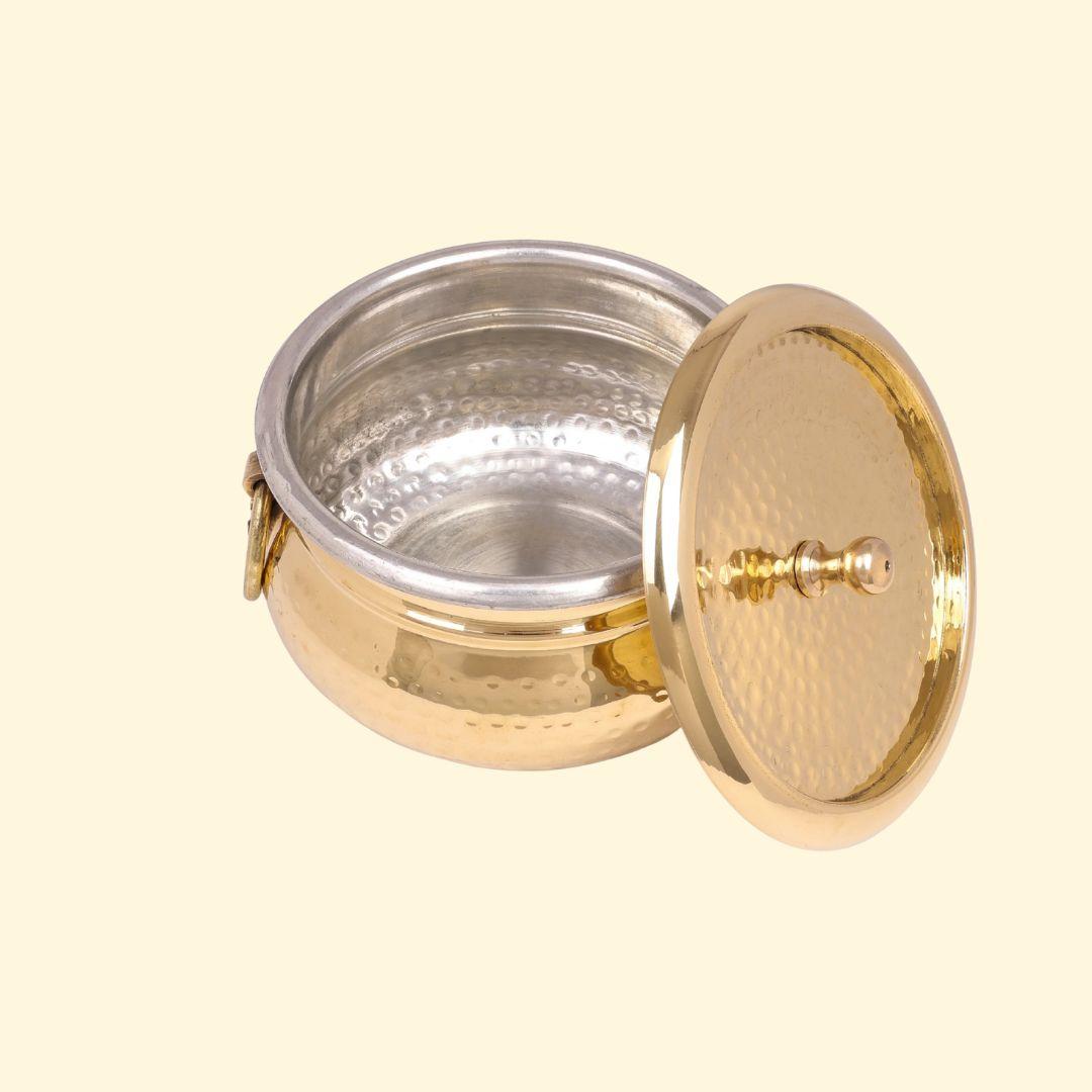 Angled view of the Classic Pot Style Brass Handi, Degchi, Patila (Pital ki handi, Pital ka Patila, Pital ke bartan) with the lid propped open. The image clearly displays the round hammered brass exterior, the attached ring handle, and the silver-colored metal lining inside the serving pot.