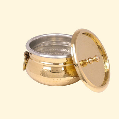 Classic Pot Style Brass Handi, Degchi, Patila (Pital ki handi, Pital ka Patila, Pital ke bartan) shown empty with the lid removed and leaning against the side. This view highlights the silver-colored metal lining on the interior, the hammered brass exterior, and one of the side ring handles.