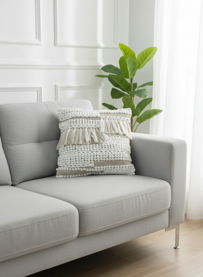 White knotted cotton cushion cover placed on a light grey sofa near a plant.