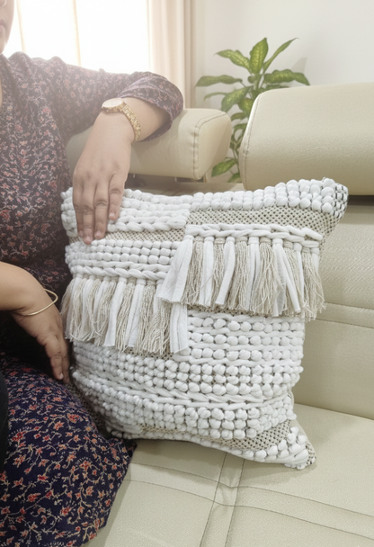 A person seated beside two beige textured cushion covers arranged on the floor.