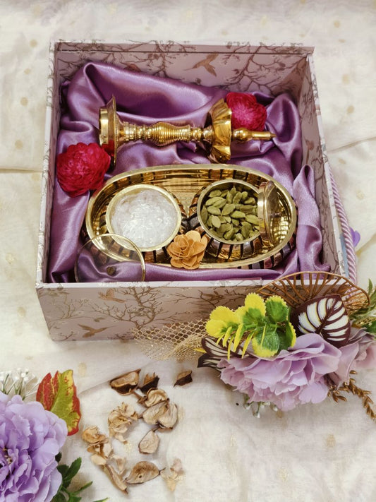 Aroma gift box displayed with a brass diya, cardamom-filled brass bowl, and 
floral accents, arranged elegantly for a festive brass gift box presentation.​