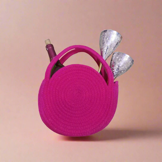 Glassy glamour gift set of 3 displayed with a bold pink circular bag carrying brass 
glasses and a wine bottle, styled as a premium gifting hamper.​