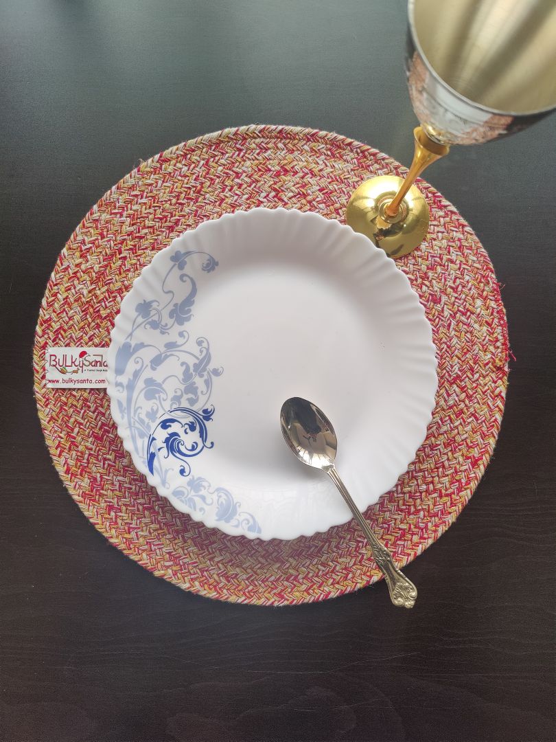 Braided round placemat used in a casual dining setting with cups and table accessories. SCRATCH & HEAT RESISTANT MAT: Protect your expensive furniture. These thick dining table heat resistant pads for Dining Table act as a highly reliable shield against hot serving bowls, accidental gravy spills, and everyday scratches, ensuring your wooden or glass dining tables remain completely safe, spotless, and worry-free.