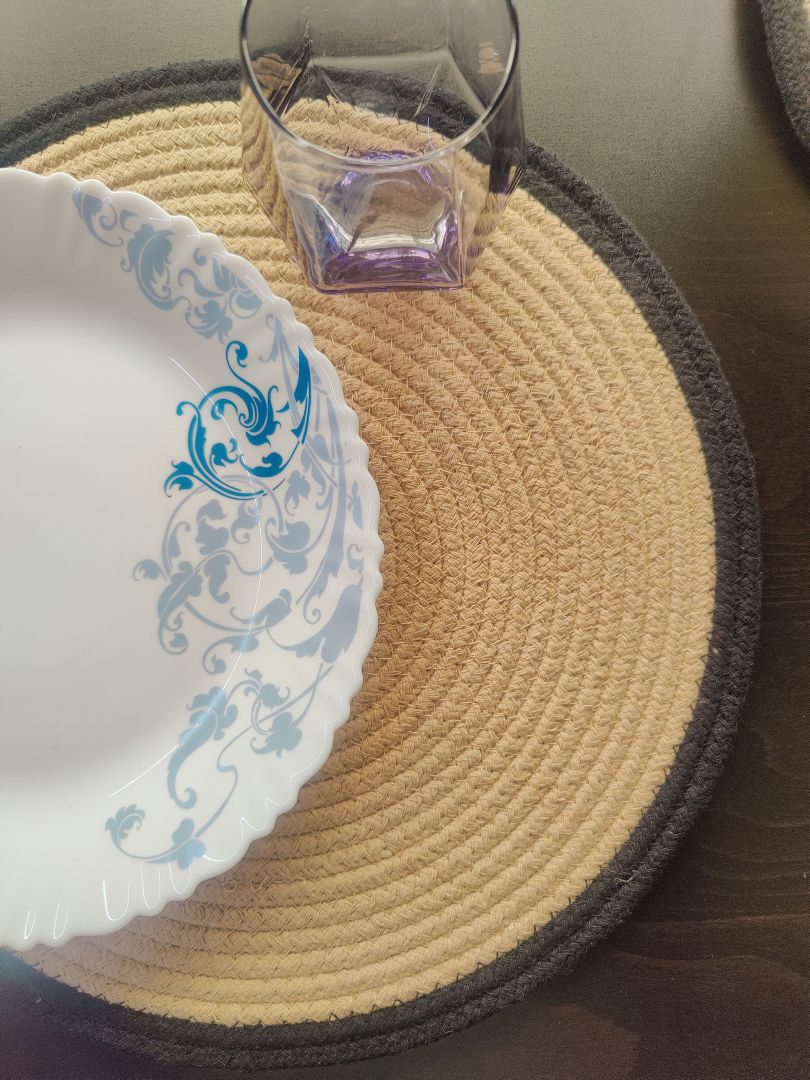 Beige braided spiral mat styled with table décor elements, used as elegant round
decorative placemats. Gift-Worthy Versatility: These placemats make thoughtful gifts for weddings or housewarmings. Also great for food heating mat for dining table, bed side table cover cloth, or side table cloth usage.