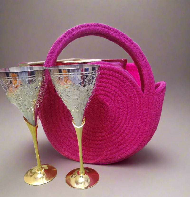 Brass glasses hamper shown with a textured pink round bag and metallic glasses, arranged as a stylish glassy glamour gift hamper for special occasions.​