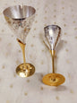 Engraved brass wine glasses with silver finish placed on table