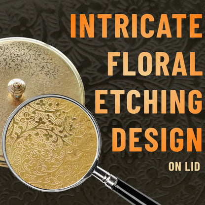 Gold lid with intricate floral etching design, magnified by a magnifying glass, on a dark textured background with text 'Intricate Floral Etching Design on Lid'.