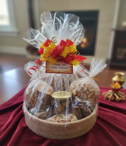 Gift basket with cookies, nuts, and a candle on a red surface.