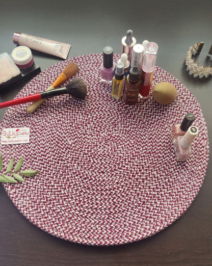 Maroon braided placemat used in a decorated dining setup with cups, flowers,
and table accessories.