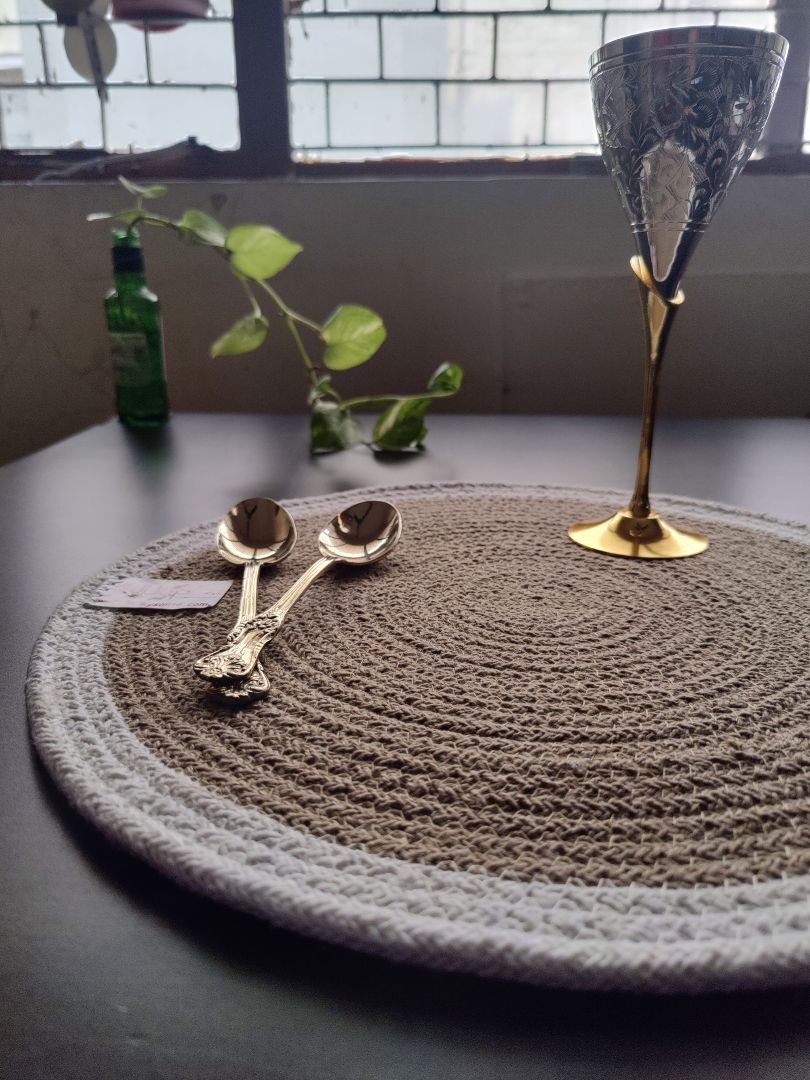 Decorated round mat featuring candles and greenery on a clean table, presenting
a cozy setting for round cotton placemats.
