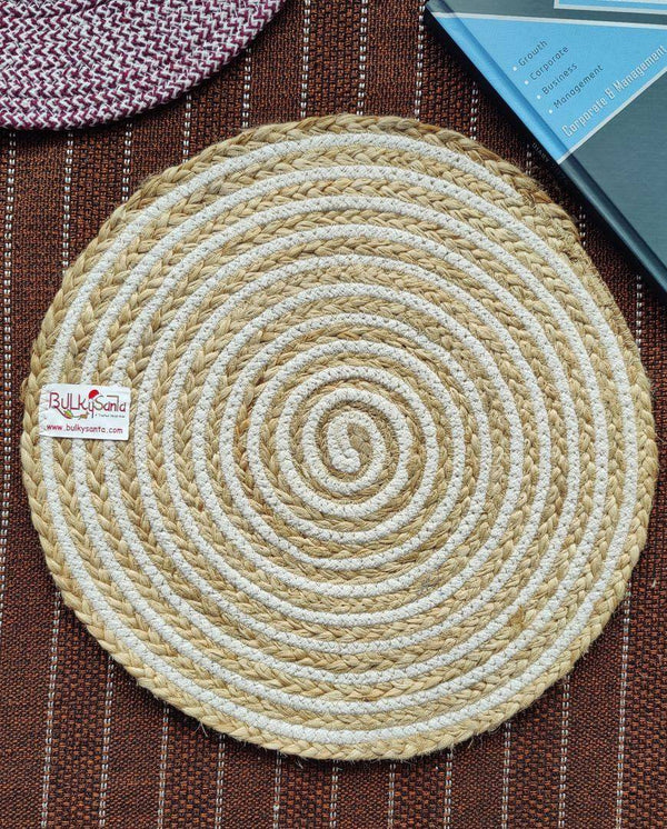 Beige and white braided jute spiral mat placed on a textured brown surface, used
as natural cotton placemats.