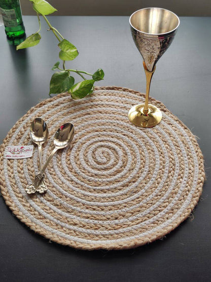 Braided spiral mat displayed with cutlery and décor on a dining setup, used as
neutral round placemats.