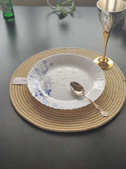 Close-up of a yellow and white woven mat on a clean table setting, adding charm as round cotton placemats.