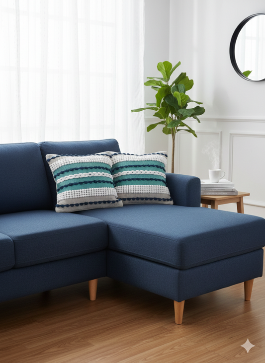 Two blue and green woven cotton cushion covers placed on a navy L-shaped sofa.