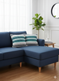 Two blue and green woven cotton cushion covers placed on a navy L-shaped sofa.