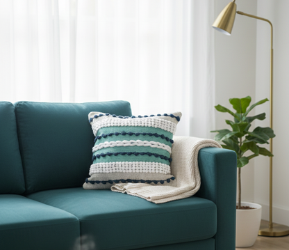 Striped green and white premium cotton cushion cover resting on a teal sofa.