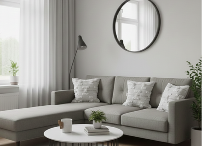 Three pale-grey patterned cotton cushion covers arranged on a living room sofa.