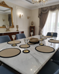 Dining setting featuring black-beige round cotton placemats, coasters and trivet
set for modern organized table decor.